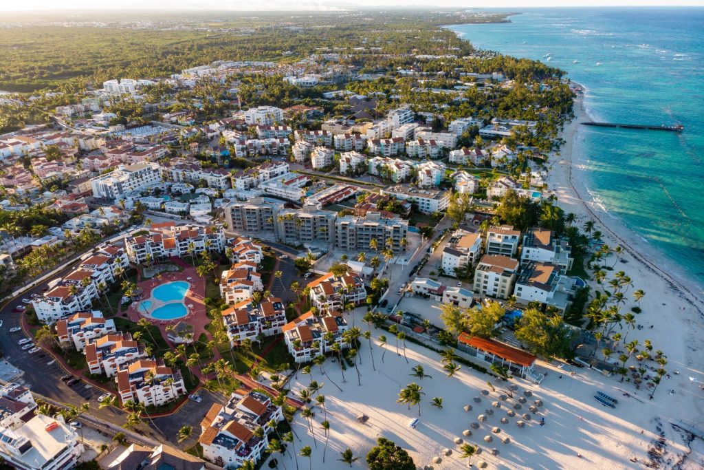 Aerial drone view of beach resort hotels with pools, umbrellas and blue water of Atlantic Ocean, Bavaro, Punta Cana, Dominican Republic