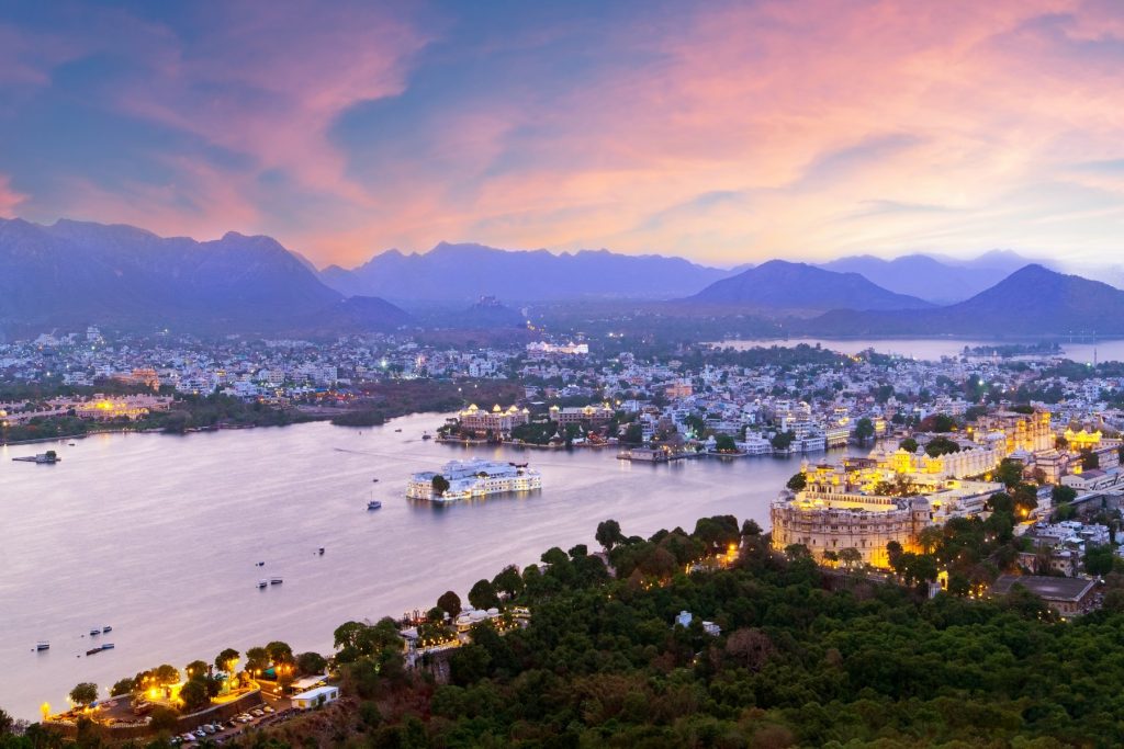 Udaipur city at lake Pichola in the evening, Rajasthan, India. View from the mountain viewpoint see the whole city reflected on the lake.