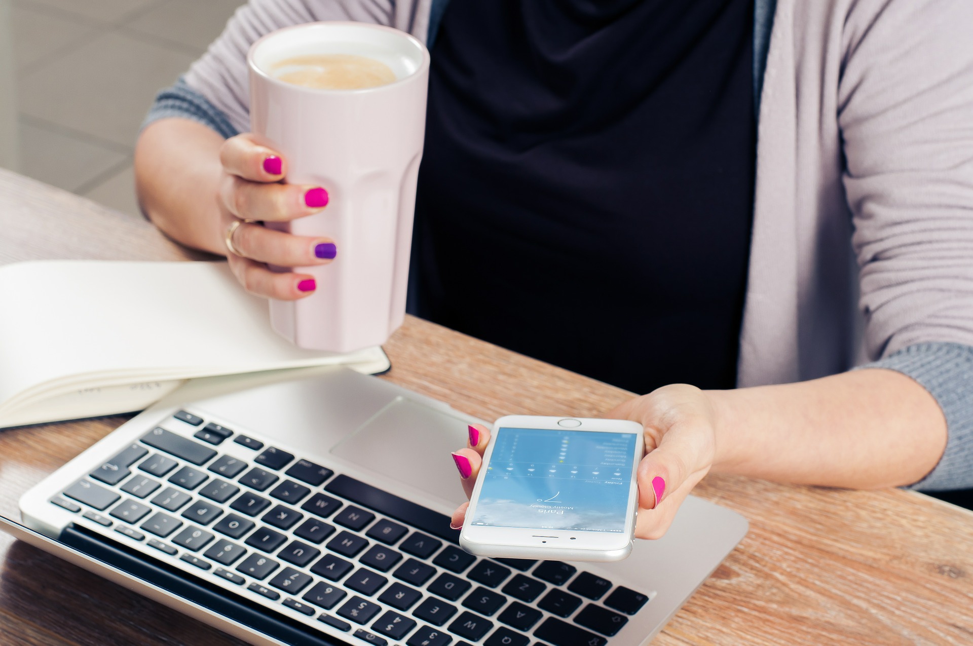 woman checking her phone at her computer
